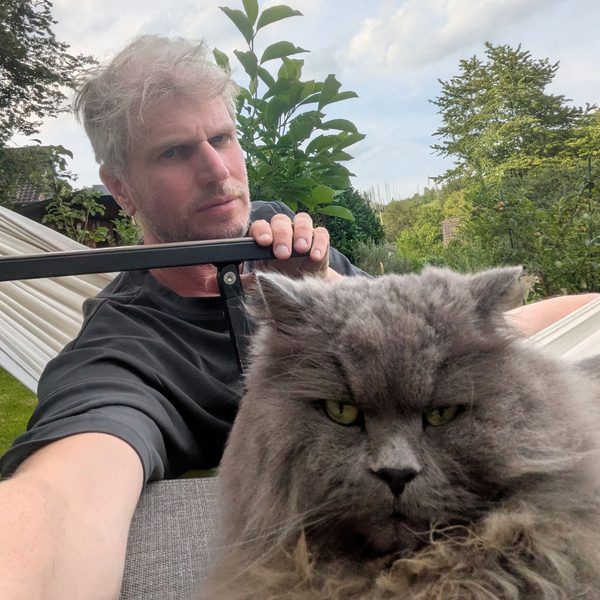 Jürgen Hermes mit Katze in der Hängematte im Garten